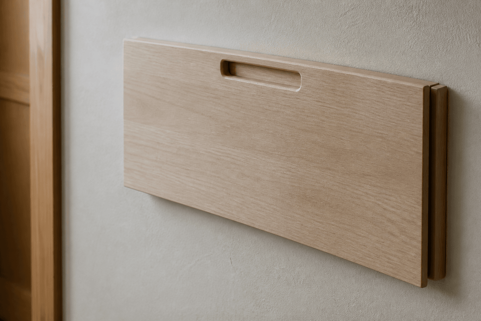 Simple timber drop-leaf table closed against a plaster wall, one chair, soft side light