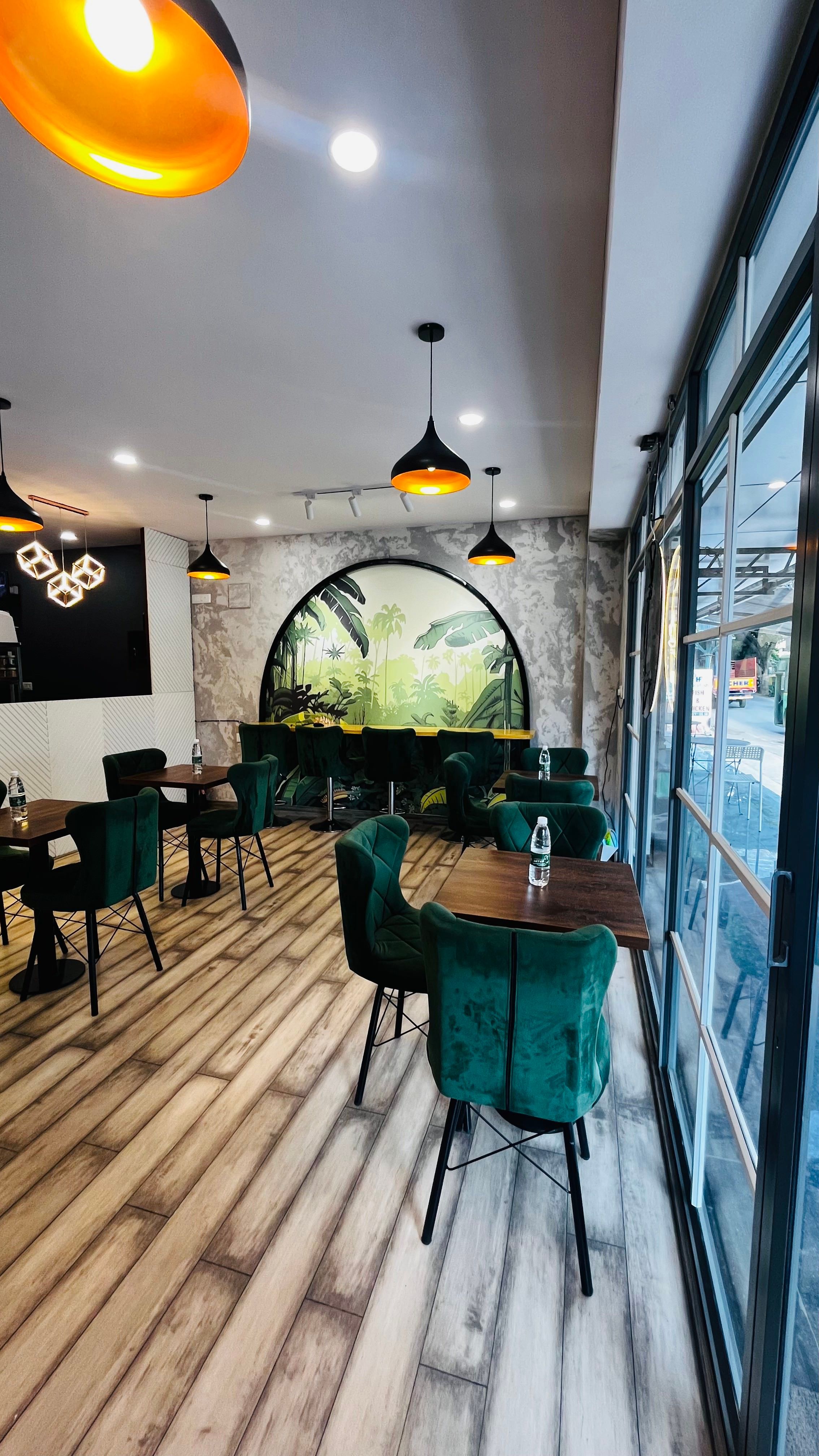 Seating with arched tropical mural and storefront glazing